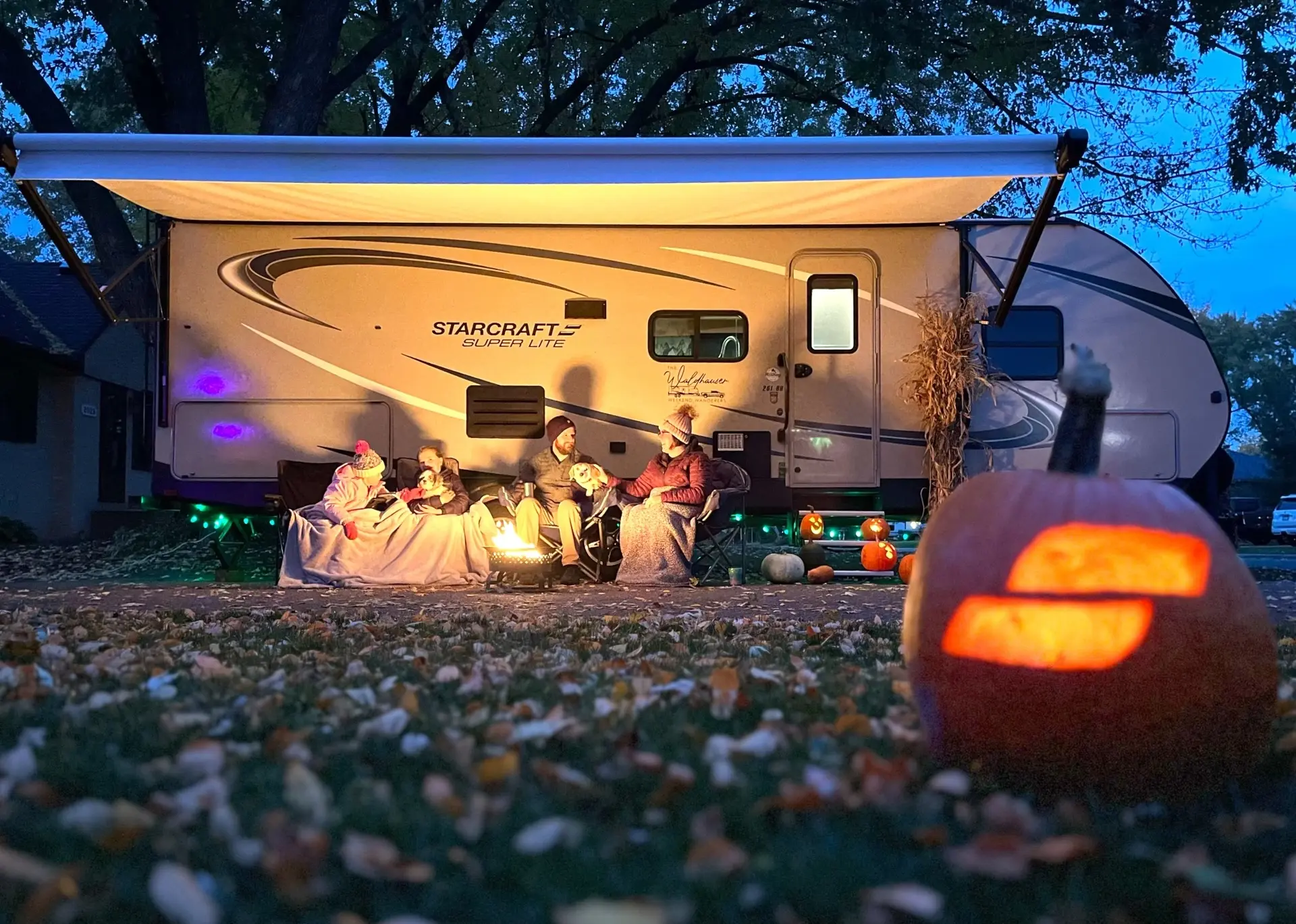 Family in Front of Camper at Night