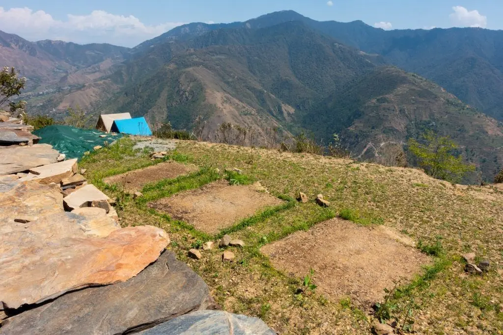 Campsite scars: Turf damage and footprints on grass after camping. Campsite on a hill top surround by Shivalik mountain range. Himalayan region in Uttarakhand . India