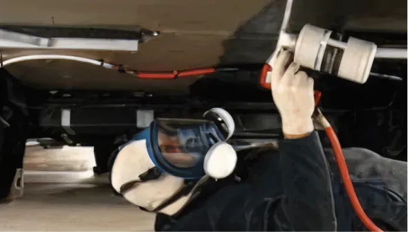 Technician performing maintenance underneath an RV vehicle.