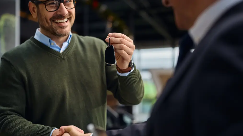 Smiling customer receiving vehicle keys from a Valpo Car Co. representative