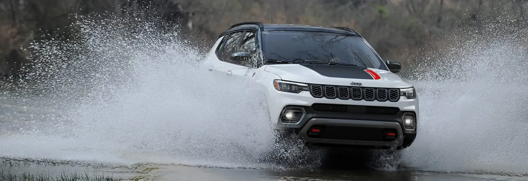 2025 Jeep Compass driving on a scenic road showcasing its rugged capability