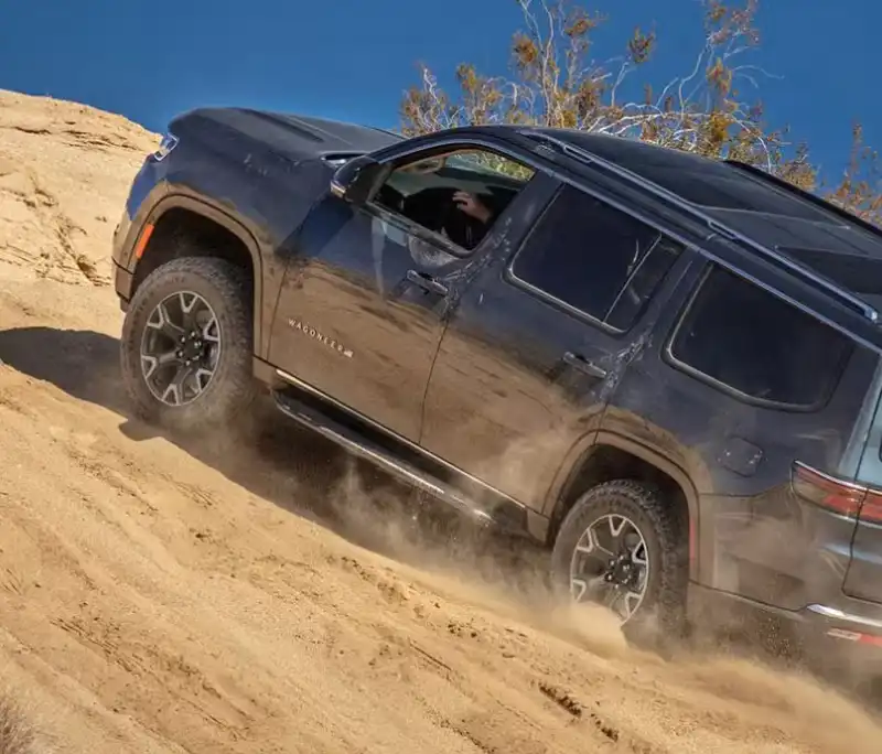 Wagoneer climbing a sandy hill on an off-road trail