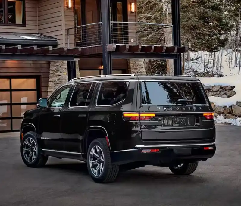 Black Jeep Wagoneer parked outside a modern home